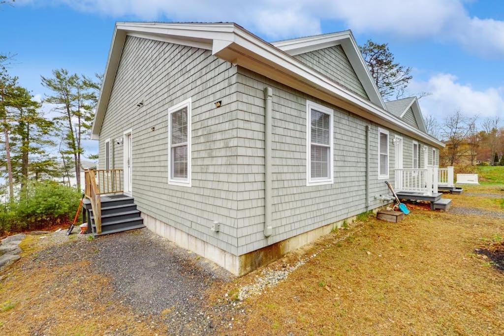 a white house with a porch and stairs on it at New Riverfront Condo in Sheepscot Harbour - Walk to Famed Seafood Eatery in Edgecomb