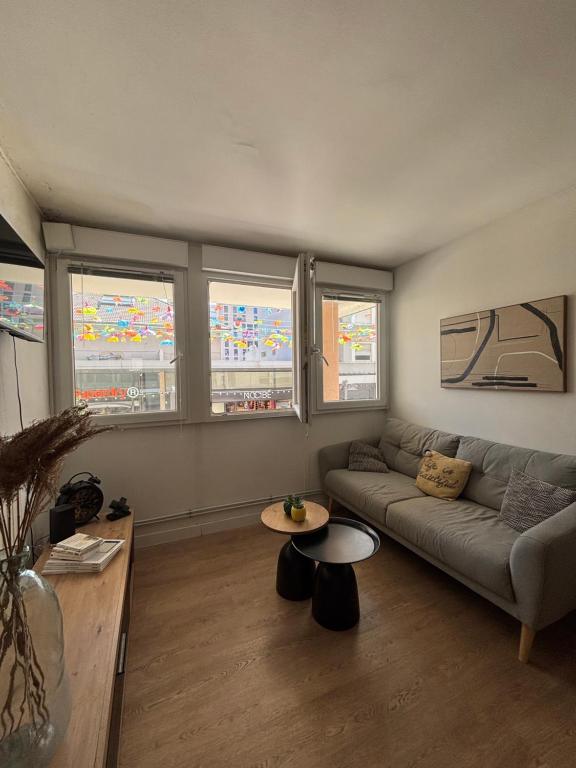 a living room with a couch and a table at La nuit calme in Annemasse