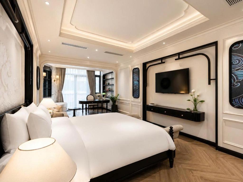 a bedroom with a large white bed and a living room at Snal Spare Hotel in Ho Chi Minh City