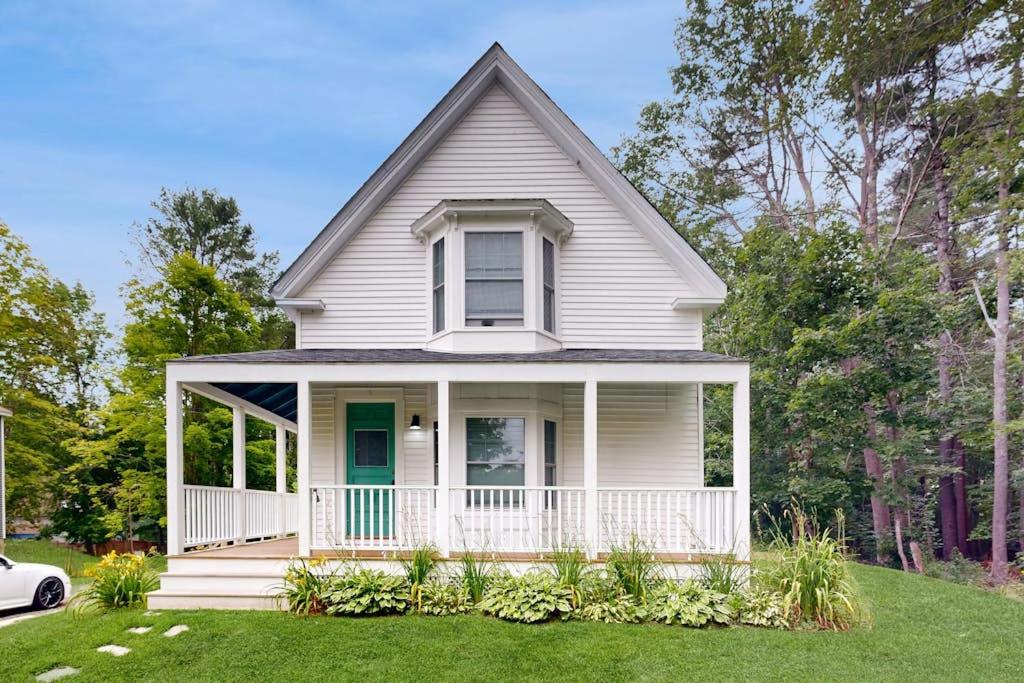 a white house with a porch on a lawn at Charming Camden Retreat with Front Porch, Deck and Wifi in Camden