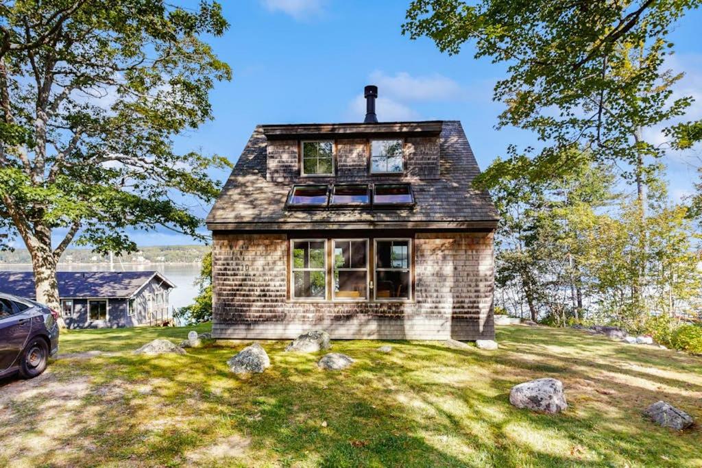 a stone house with a car parked in the yard at 2 Waterfront Cottages in Ocean Point with Dock & Large Yard, Dog friendly in East Boothbay