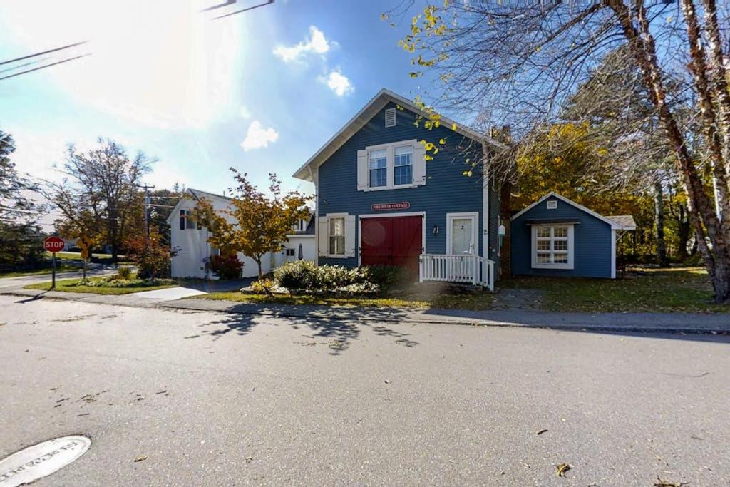 a blue house with a red door on a street at Historical New England home, outdoor shower , Dog-friendly in Boothbay Harbor