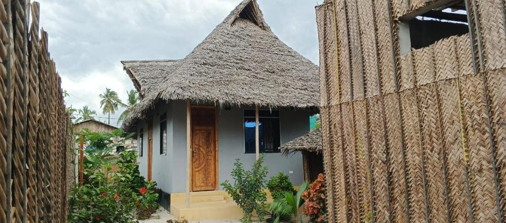 a small house with a thatched roof and a doorway at Zamani Matemwe House in Matemwe
