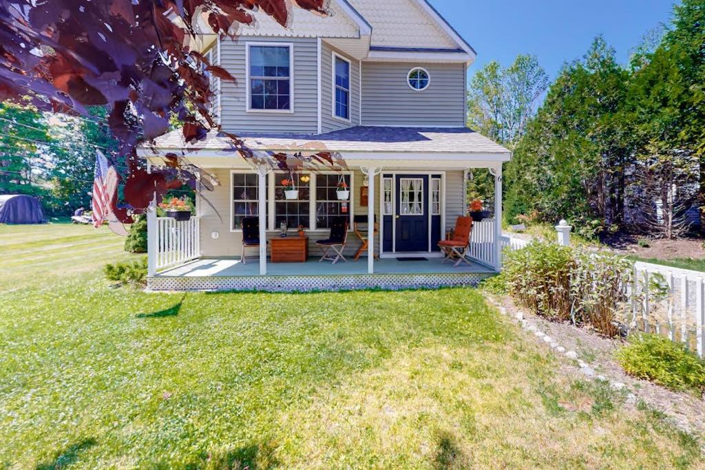 a small house with a porch and a yard at Two-story home steps from Laite Beach - stroll to the harbor, 1 dog welcome in Camden