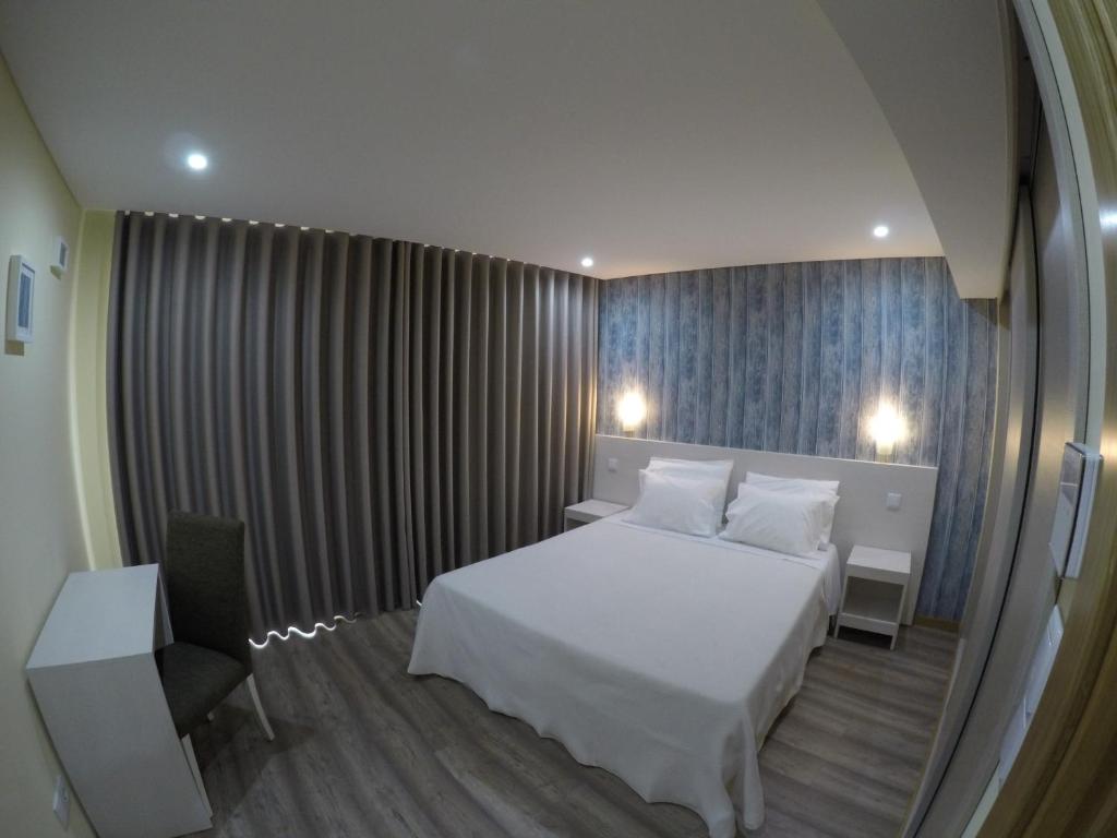 Habitación de hotel con cama y espejo en Ardínia the Legend, en Lamego