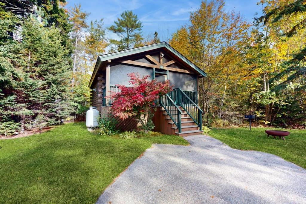 a small house with a staircase in the grass at Charming dog-friendly studio cabin with firepit and near outdoor fun in Northport