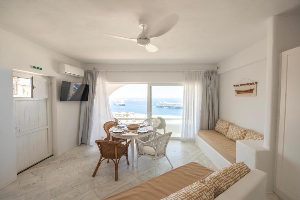 a living room with a table and a couch at Eagles Nest Mykonos Suites & Apartments - Shared Pool & Jacuzzis in Mikonos