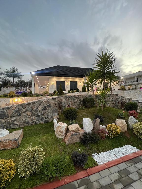 a house with a rock garden in front of it at Hemin's Greenery Villa in Erbil