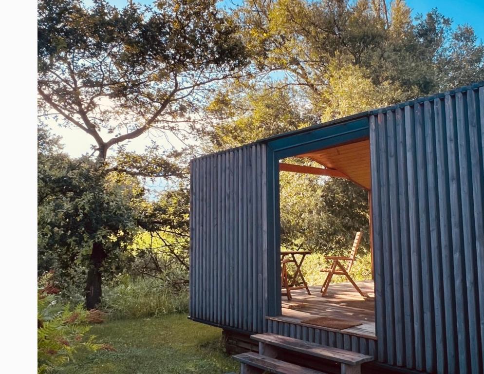 a tiny house with a large window on a deck at 206 The tiny "Office" House in Bleckede