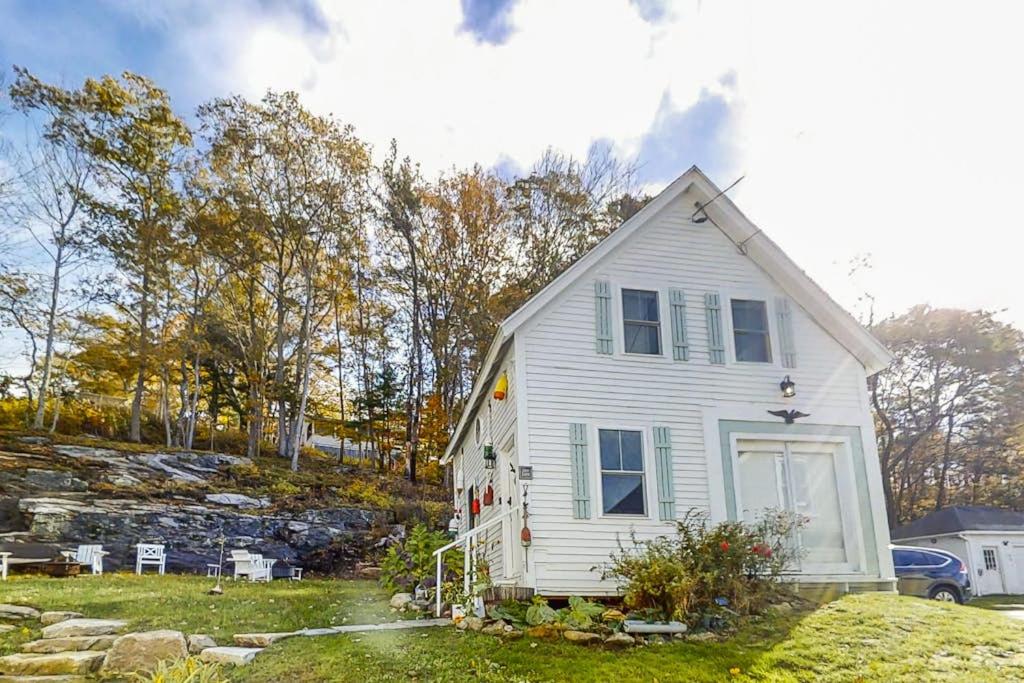 a white house sitting on top of a yard at Iconic downtown retreat with firepit & fireplace- walk to Harbor Footbridge in Boothbay Harbor
