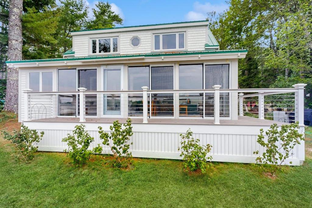 a large white house with a white fence at Charming Oceanfront Home with Stunning Water Views and Wifi in Georgetown