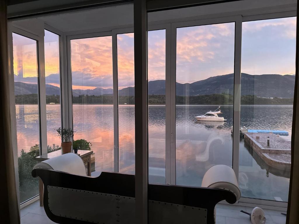 a room with a view of a boat in the water at Aquamarine House in Tivat