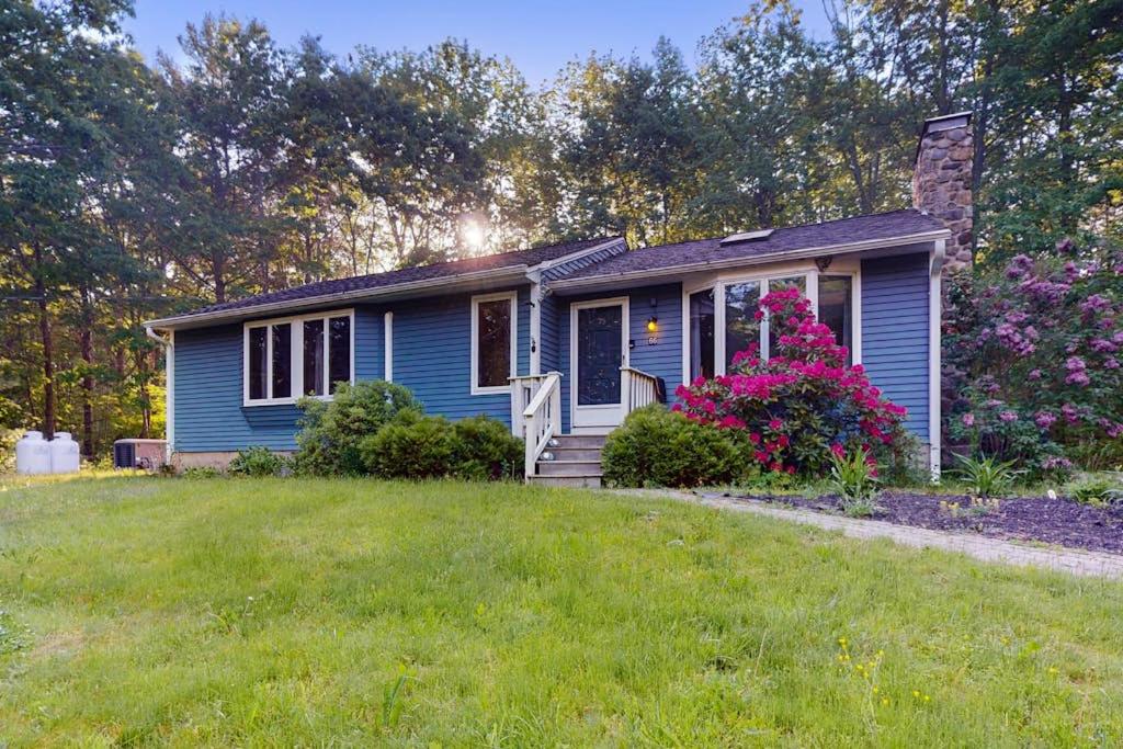 a blue house with a lawn in front of it at Tree-lined home with screened porch & perfect Midcoast location in Damariscotta