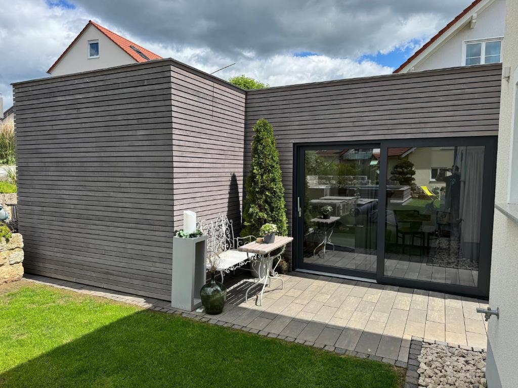 a house with sliding glass doors and a patio at Secret Garden Spa House - Pool & Sauna in Großenlüder