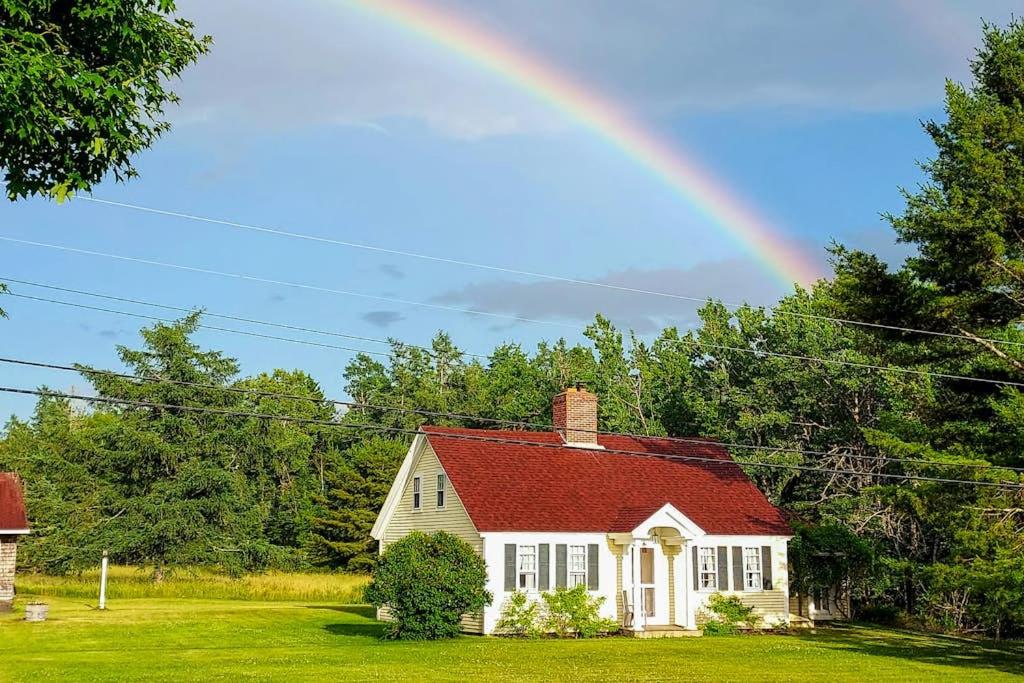 a rainbow over a white house with a red roof at Charming Seaside Cottage with a Gas Fireplace, Spacious Patio, and Nearby Hiking in Hancock
