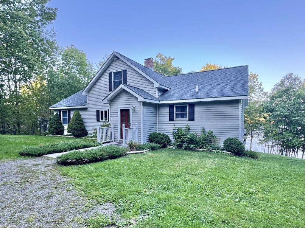 a white house with a yard at Riverfront home w/ deck, amazing views & firepit - near the best of Maine in Stockton Springs