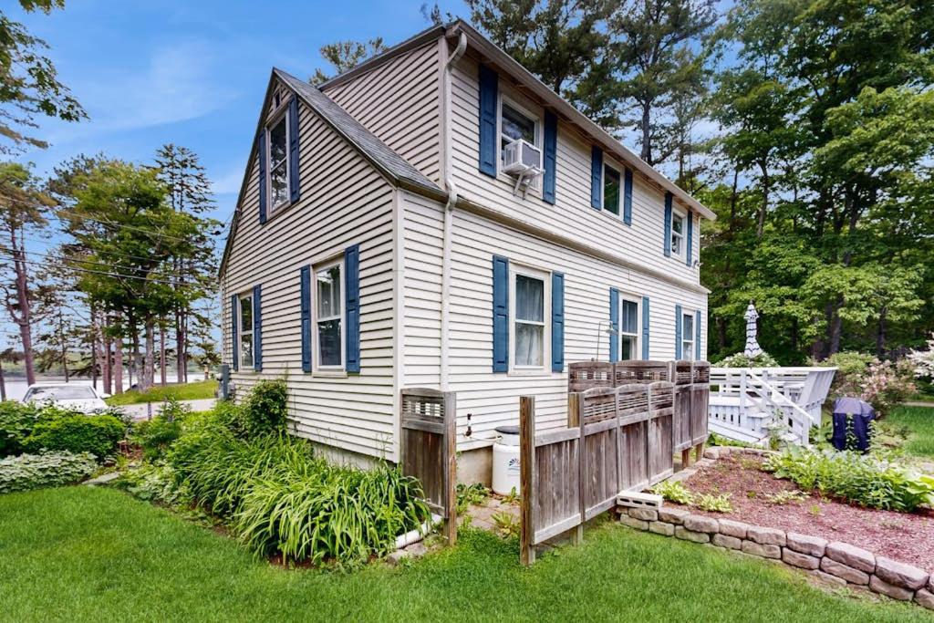 a white house with a fence in the yard at Tranquil Seaside Cottage with Spectacular Views, Wifi & Washer/Dryer in Boothbay