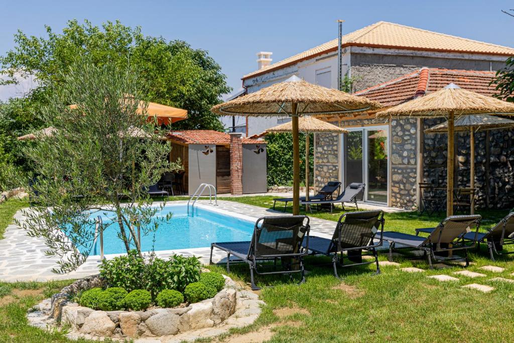 a house with a swimming pool with chairs and umbrellas at Villa Sofia in Evkarpía