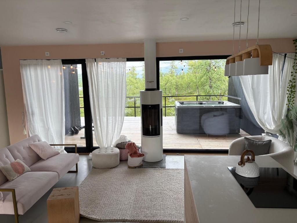 a living room with a couch and a bath tub at Sunrise View Lapland, Jacuzzi and sky view in Kilpisjärvi