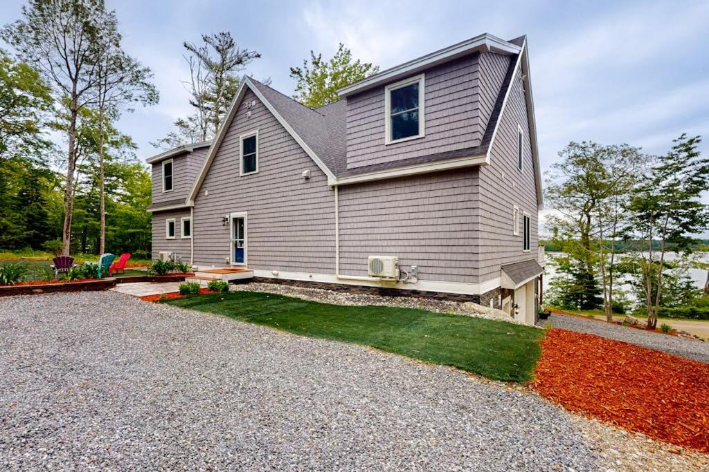 a house with a gravel driveway in front of it at Luxurious waterfront home with deck, firepit, hot tub, fireplace, & pool table in Boothbay