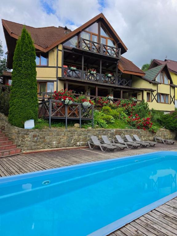 a house with a swimming pool in front of a house at 12 Місяців-Травень in Slavske