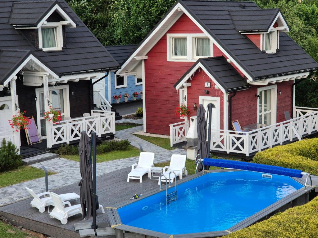 a house with a swimming pool in front of it at Domki i Apartamenty Cicha Dolina - jacuzzi, sauna, basen in Szczyrk
