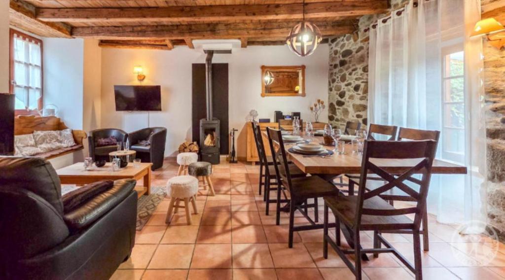 a living room with a table and a fireplace at La Maison d'Aimée in Vielle-Aure
