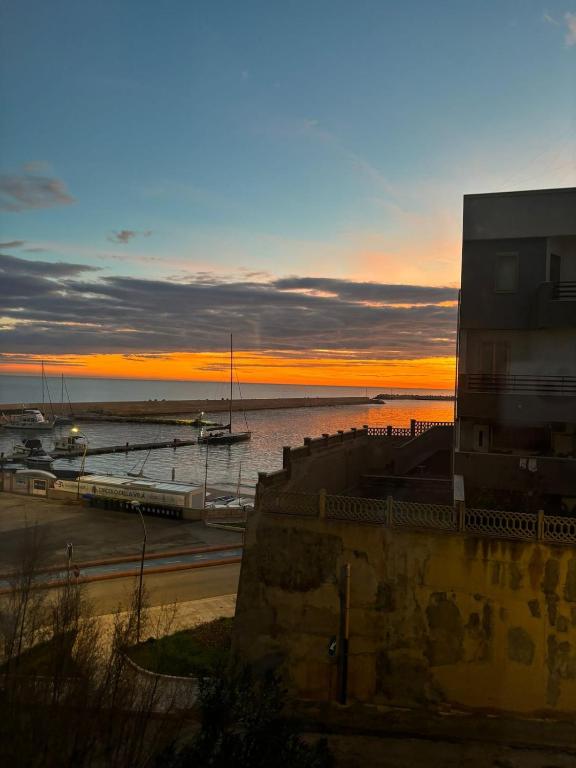 a sunset over a beach with boats in the water at appartamento in Bisceglie