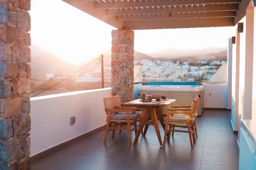 a table and chairs on a balcony with a view at Enki's Heaven Premium Apartments in Glinádhon