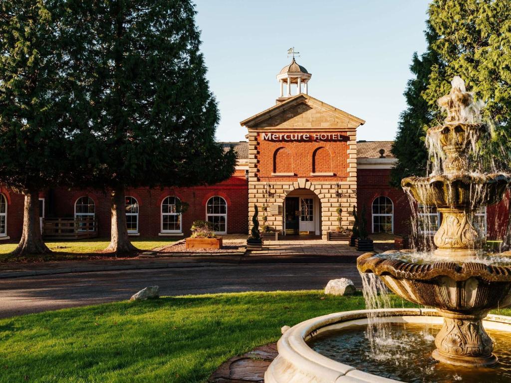 a fountain in front of a brick building at Mercure Haydock Hotel in Haydock