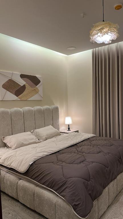 a bedroom with a large bed in a room at غرفة وصالة دخول ذكي in Al Fayşalīyah