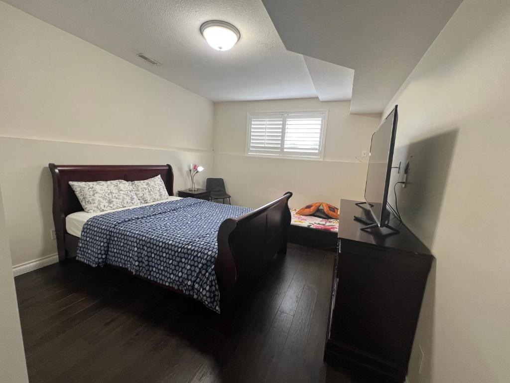 a bedroom with a bed and a flat screen tv at Luxurious Vacation in Welland