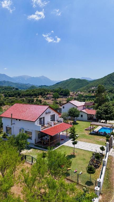 a white house with red roofs and a yard at Guesthouse Micaj LA KRIDEA in Himare