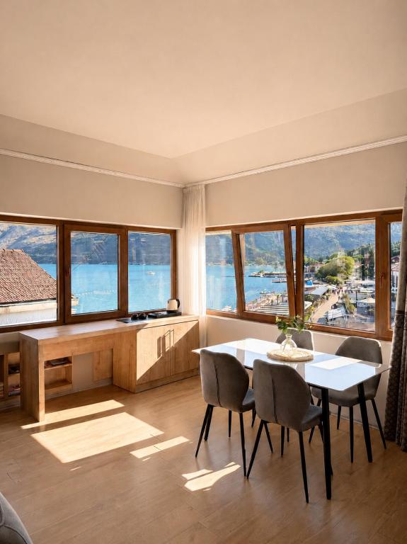 a living room with a table and chairs and windows at 101 Apartments in Igalo
