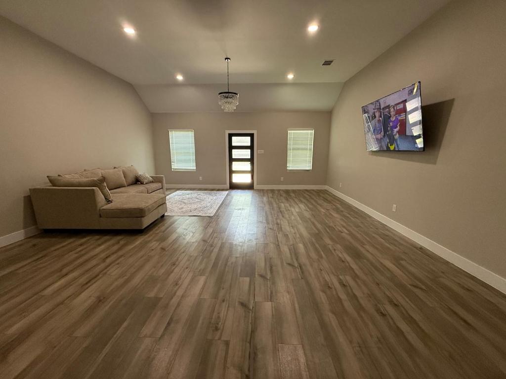 a living room with a couch and wood floors at Matthews Blue House in Wilmer