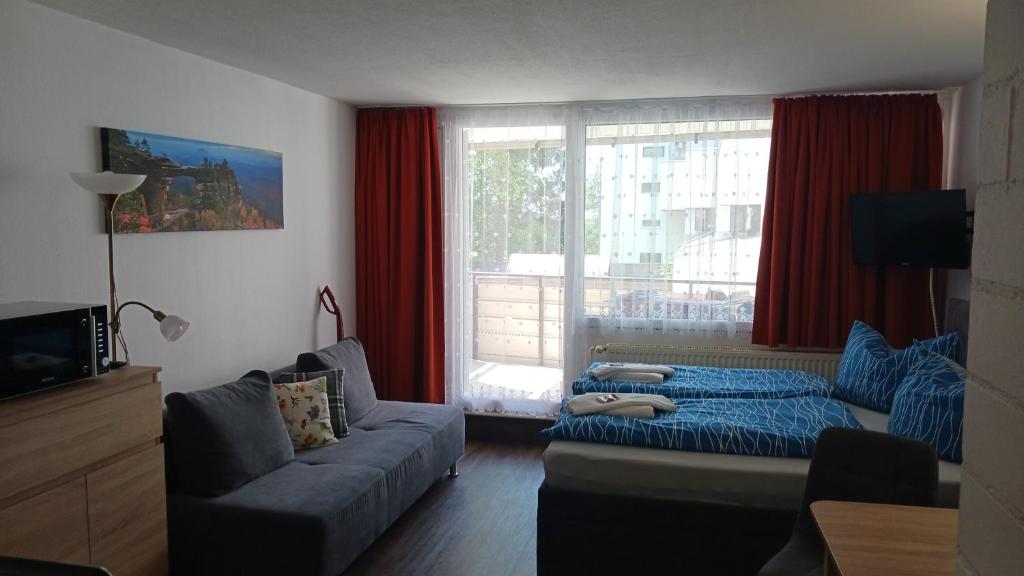 a living room with a couch and a window at App MAJA Am Predigtstuhl in Sankt Englmar