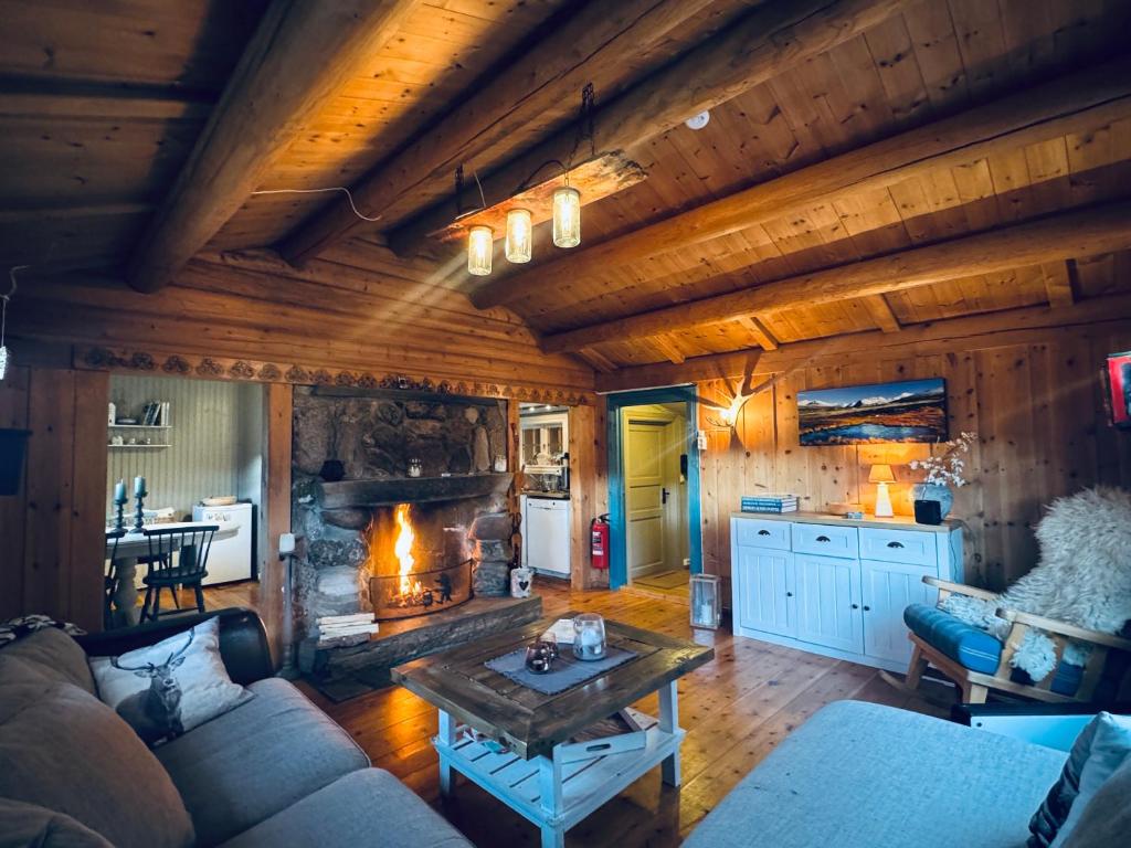 a living room with a couch and a fireplace at Atmospheric cabin by Lesjaskogsvatnet in Lesja