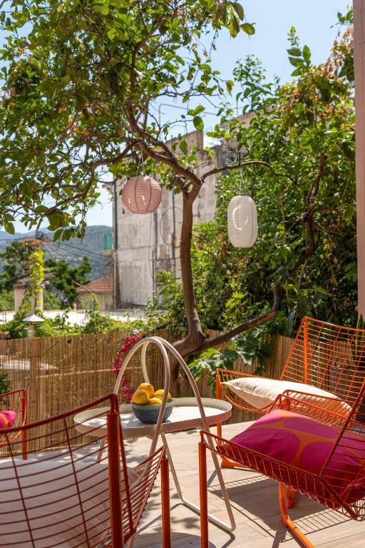a patio with chairs and a table with a bowl of fruit at Art and Light in Argostoli