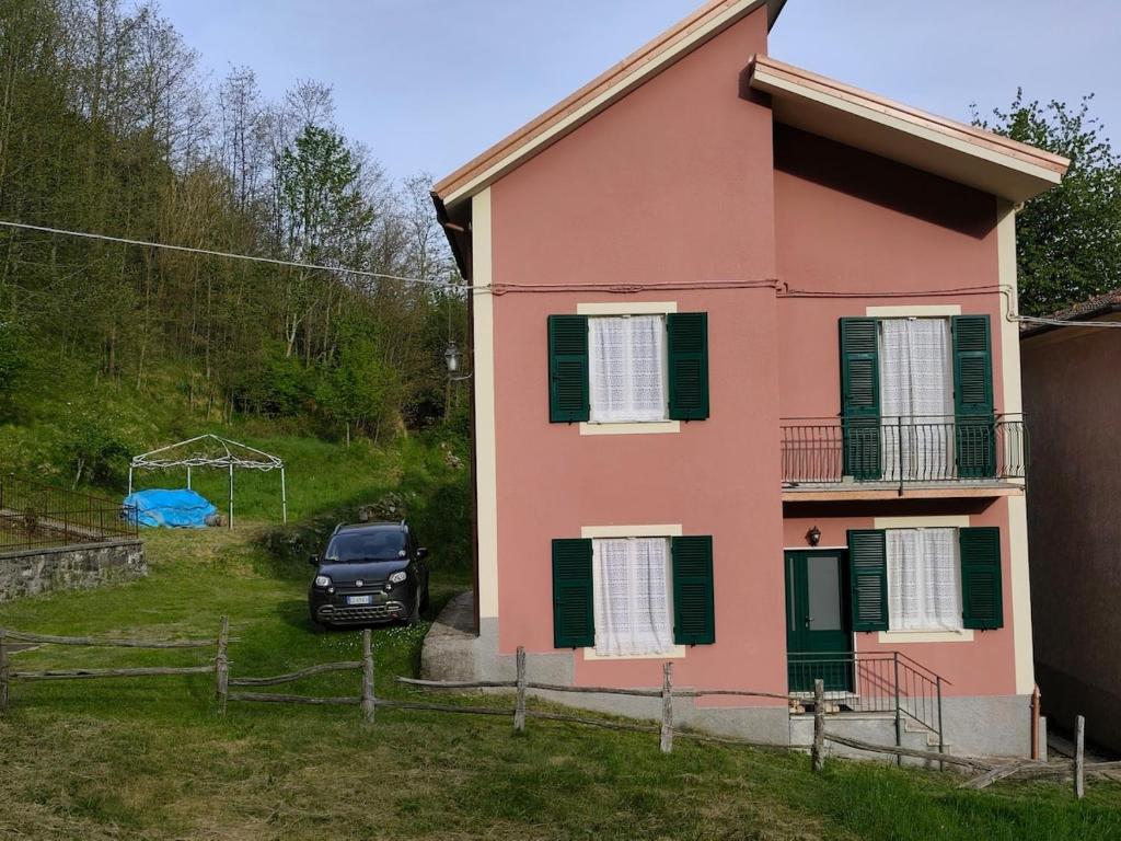 a pink house with a car parked next to it at Casa Roncopiano in Cabanne