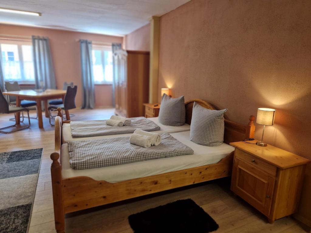 a bedroom with two beds and a table at Gästehaus La Puccia in Mittenwald