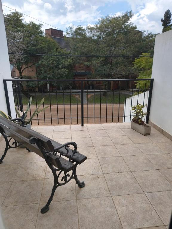 a bench sitting on a patio with a fence at Duplex EyC in Colón
