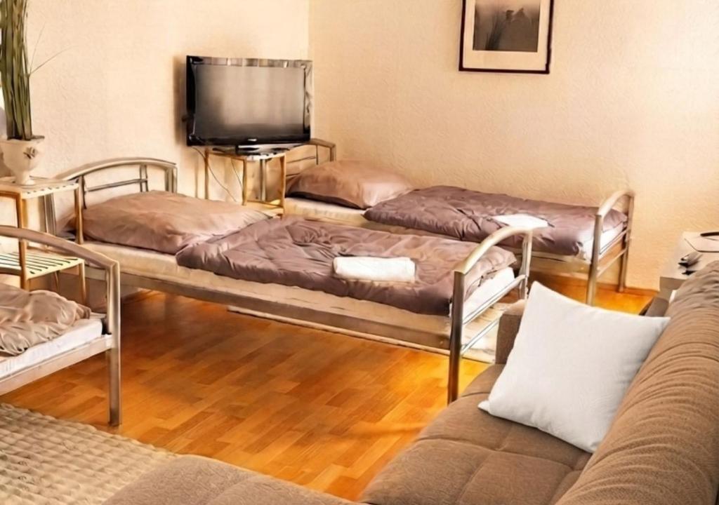 a living room with three beds and a flat screen tv at Harzer Domschatz-Auszeit Monteure - Einzelbetten in Halberstadt