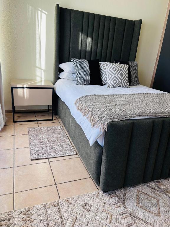 a large bed with a black headboard in a room at Airport Urban Studio in Benoni
