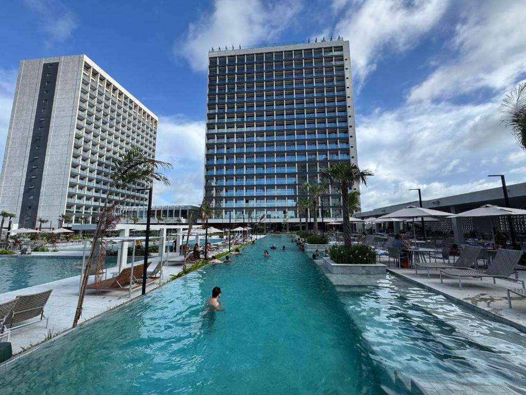 a person in a swimming pool in front of a building at Salinas Beach Resort in Salinópolis
