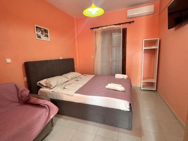 a bedroom with orange walls and a bed with towels on it at House Nativa in Mola Kalyva
