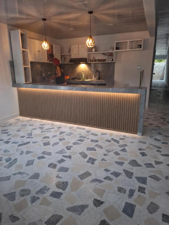 a kitchen with a counter and a woman in a kitchen at Casa con 3 habitaciones in Barranquilla
