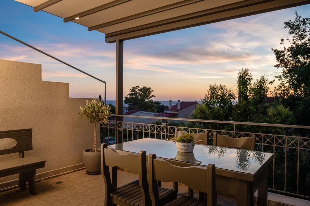 a patio with a table and chairs on a balcony at Blue Horizon luxury residence in Kanali