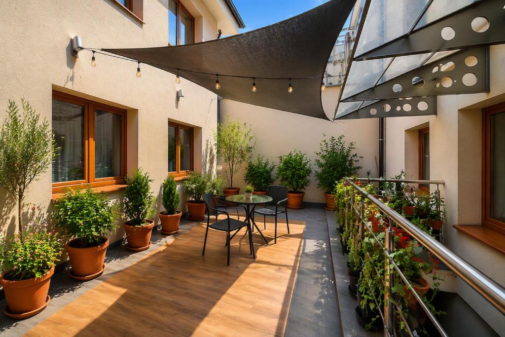 a patio with a table and potted plants at Apartmány Centrum Trenčín - Greenyard in Trenčín