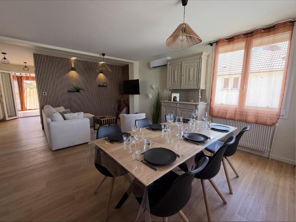 a dining room table with chairs and a living room at Meublé de Tourisme Le Swing in Marsannay-la-Côte