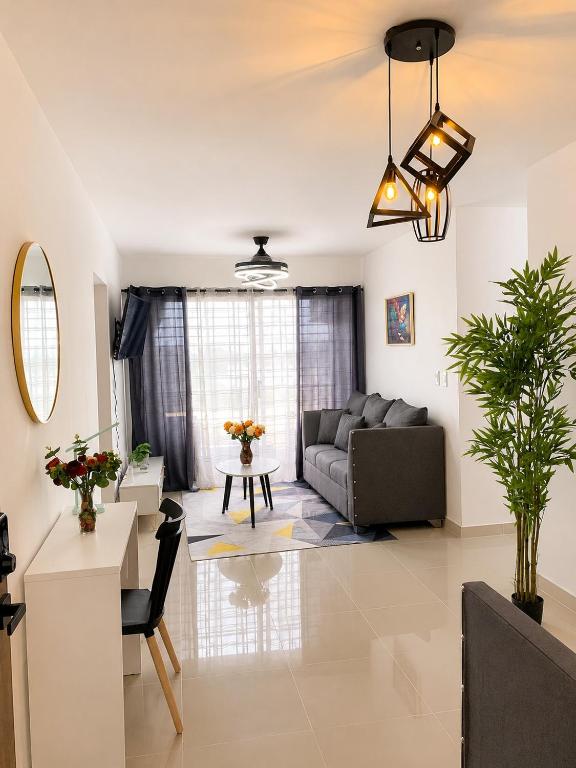 a living room with a couch and a table at Tropical Pearl Getaway in Los Paredones
